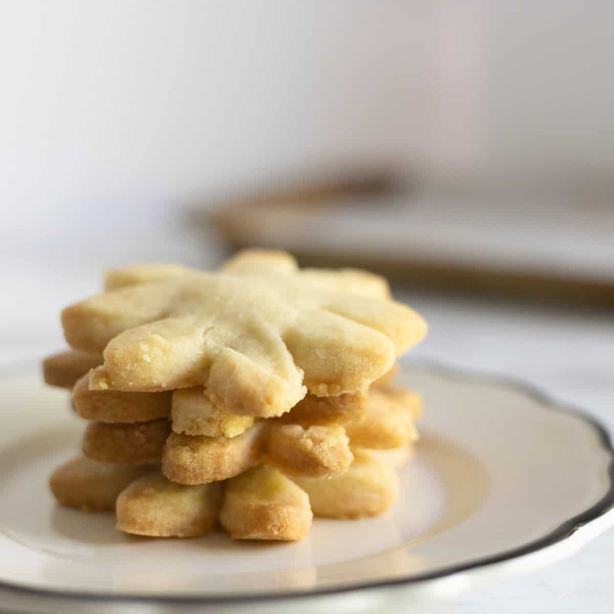 Plate of four stacked butter cookies on a small plate.