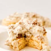 Biscuits and gravy on white plate.