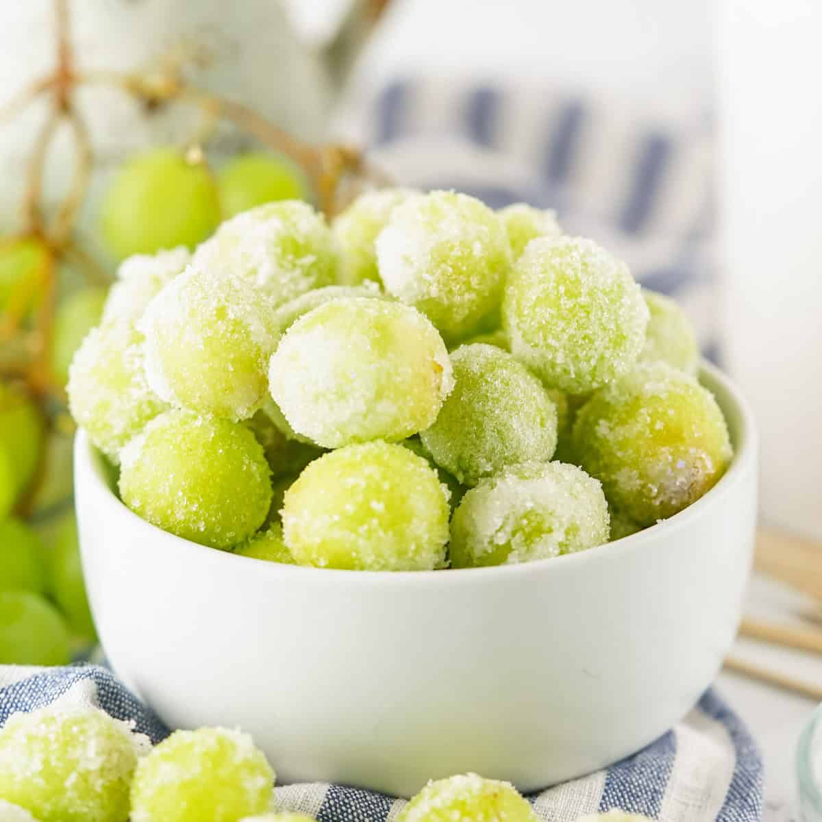 Green sugar coated grapes in white bowl.