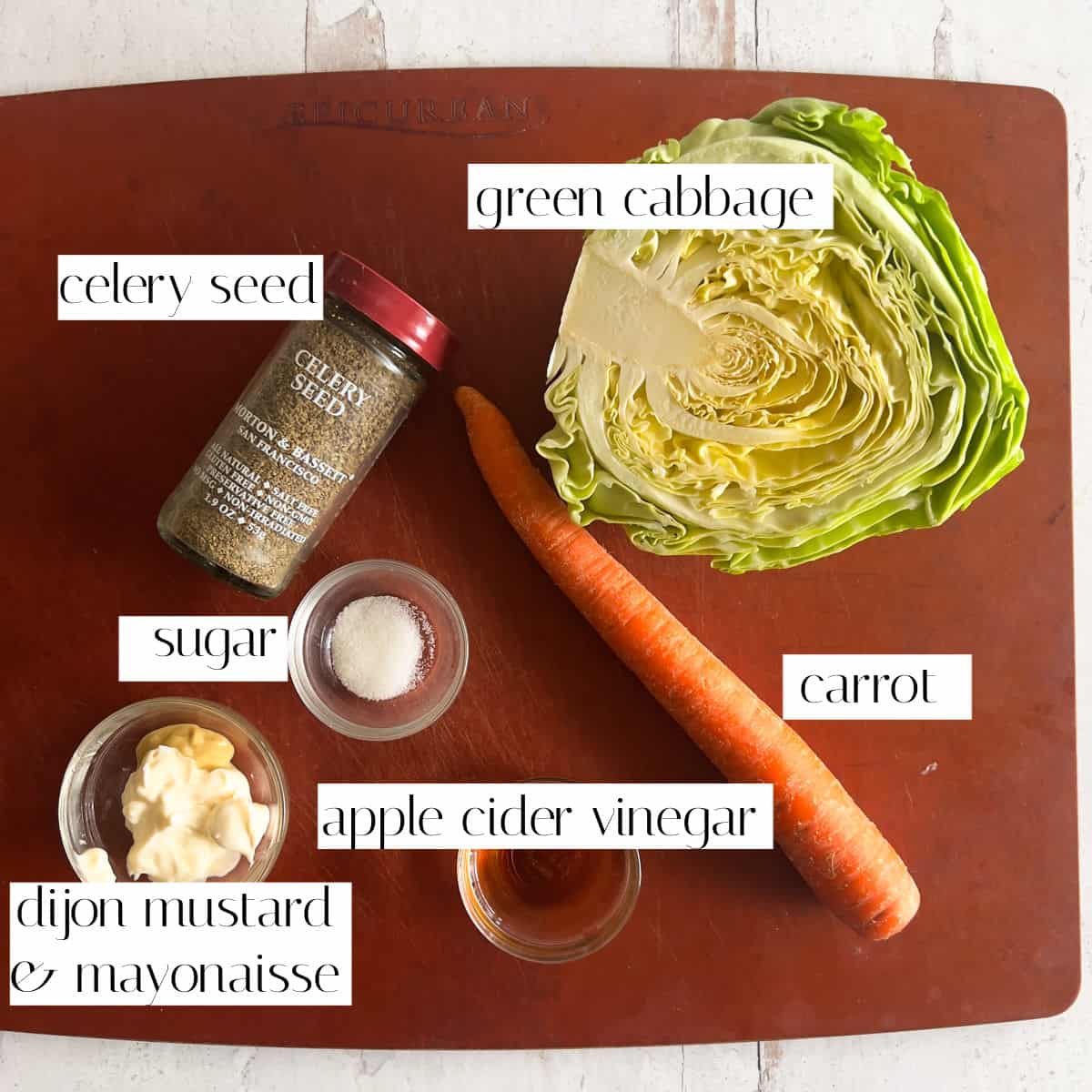 Cabbage, carrot, celery seed, mayo, mustard, apple cider vinegar, and sugar on cutting board.