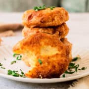 Stack of potato fritters with a sour cream sauce dripping down.
