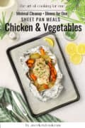 Baked chicken in foil on a bed of vegetables.