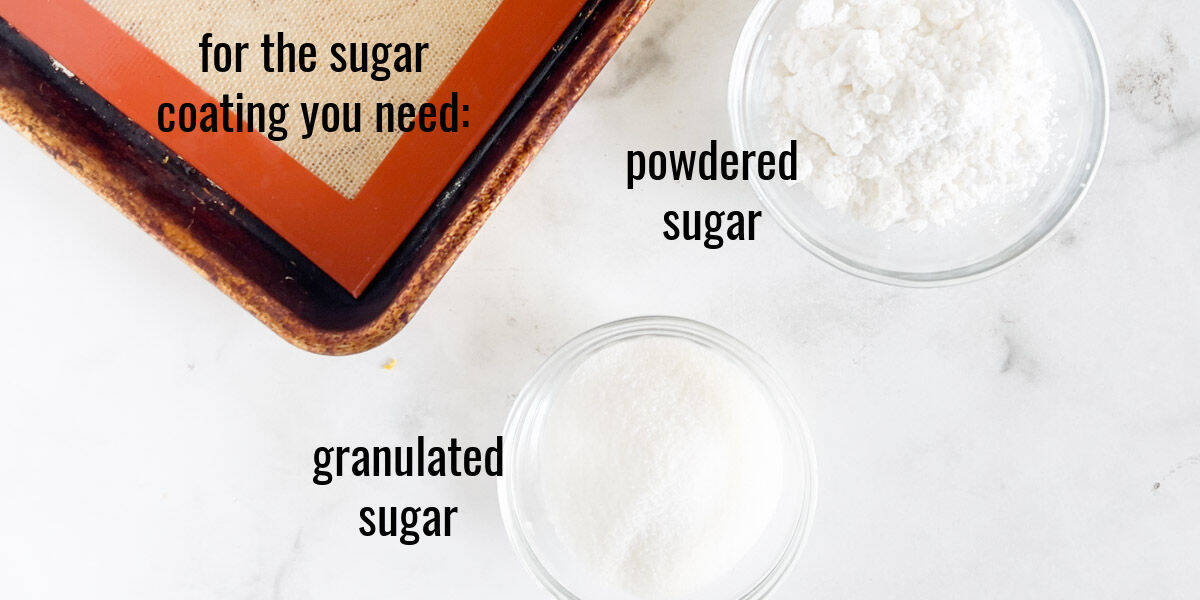 A baking tray with a silicone mat is on the left, and two bowls containing powdered sugar and granulated sugar are labeled on the right.