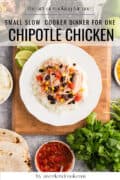 Overhead view of chipotle chicken with rice, black beans, corn, and tomatoes on a white plate, surrounded by salsa, tortillas, cilantro, and lime wedges.