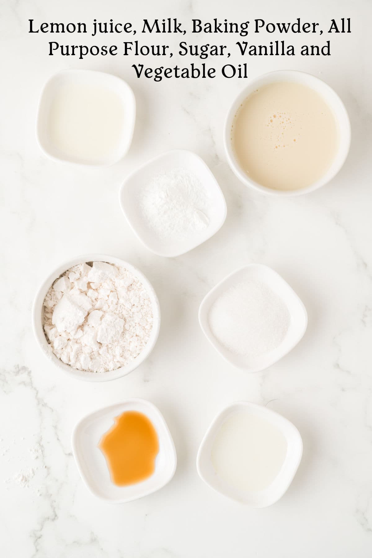 Six small white bowls with lemon juice, milk, baking powder, flour, sugar, vanilla, and vegetable oil arranged on a white marble surface. Text above lists the ingredients.