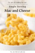 A close-up of a forkful of creamy macaroni and cheese being lifted from a small white ramekin, with text overlay about single serving mac and cheese.