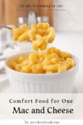 A fork lifts cheesy macaroni from a white ramekin filled with macaroni and cheese; text reads Comfort Food for One: Mac and Cheese.