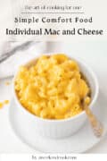 A bowl of creamy macaroni and cheese with a spoon, placed on a white surface next to a cloth napkin. Text above reads, Simple Comfort Food Individual Mac and Cheese.