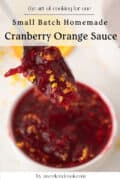 A spoon holds cranberry orange sauce with orange zest above a bowl of the same sauce; text promotes a small batch homemade recipe.