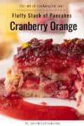 Close-up of a fluffy stack of cranberry orange pancakes topped with cranberry sauce, with visible orange zest and berries—perfect Cranberry Pancakes for a cozy weekend cooking recipe.
