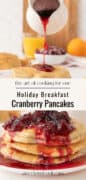 A stack of cranberry pancakes topped with cranberry sauce being poured from a small pitcher, with orange juice and fruit in the background. Text overlay reads Holiday Breakfast Cranberry Pancakes. Perfect pancakes for one!.