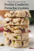A stack of four cranberry pistachio cookies on a white plate, with visible pieces of cranberries and pistachios. Text above and below describes the cookies.