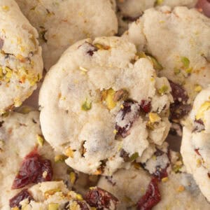 A close-up view of crumbly cranberry cookies with visible pistachio pieces and dried cranberries.