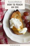 A poached egg on toasted bread with red grapes on a white plate, next to a red and white checkered cloth. Text above reads How to Poach an Egg.