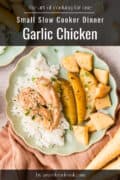 A plate with garlic chicken, white rice, and cooked potato wedges, shown from above on a green scalloped plate. Text reads: Small Slow Cooker Dinner Garlic Chicken.