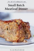 A close-up of two slices of meatloaf on a white plate, with text above reading Small Batch Meatloaf Dinner.