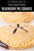 Two round blueberry pie cookies with golden, crimped edges and slits on top, their sweet blueberry filling peeking out at the edge.