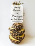 A pineapple cut into horizontal slices and stacked, with text overlay: Using canned or fresh pineapple in recipes aweekendcook.com.