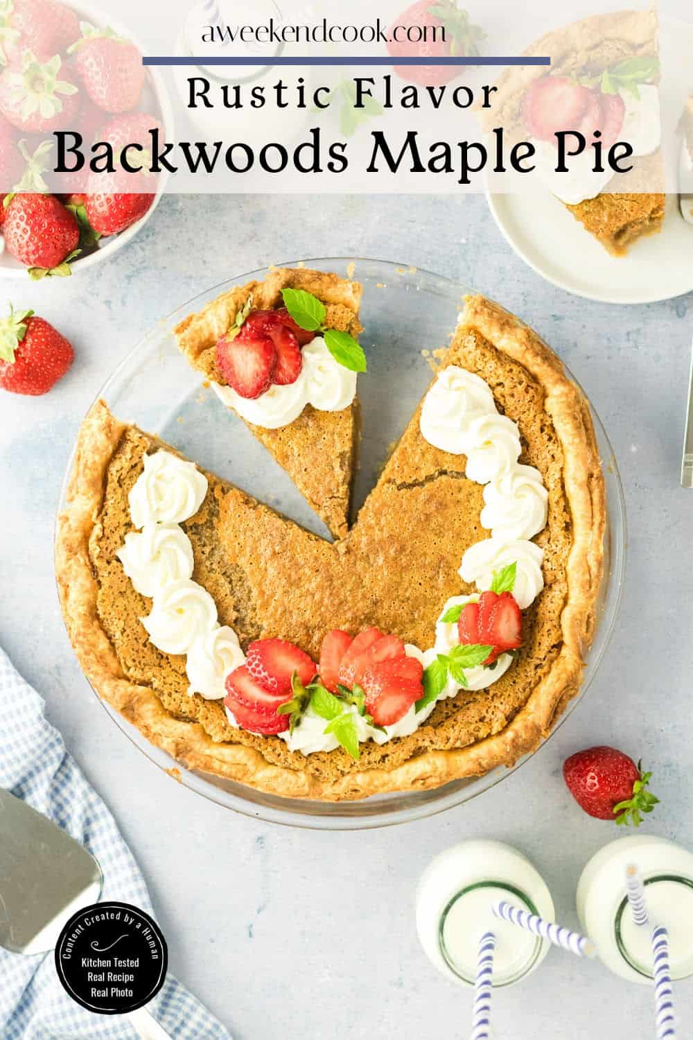 A sliced maple pie with whipped cream and strawberries on top, surrounded by fresh strawberries, two milk bottles, and a pie server on a light blue surface.