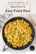 A pan of easy fried rice with scrambled eggs, peas, carrots, and corn.